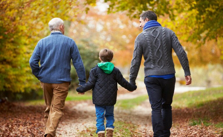 Vista traseira de uma família masculina de várias gerações caminhando no caminho