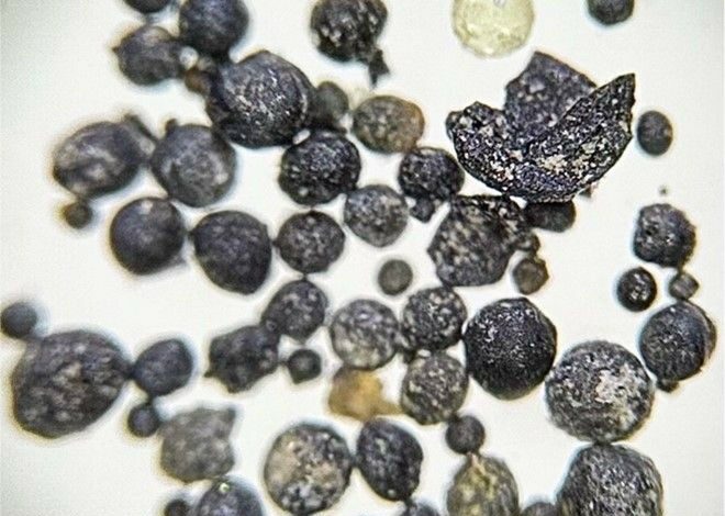 Micrometeoritos recuperados das montanhas da Bélgica, escala no topo da imagem