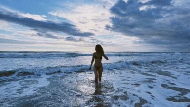 Lily James parada na praia.