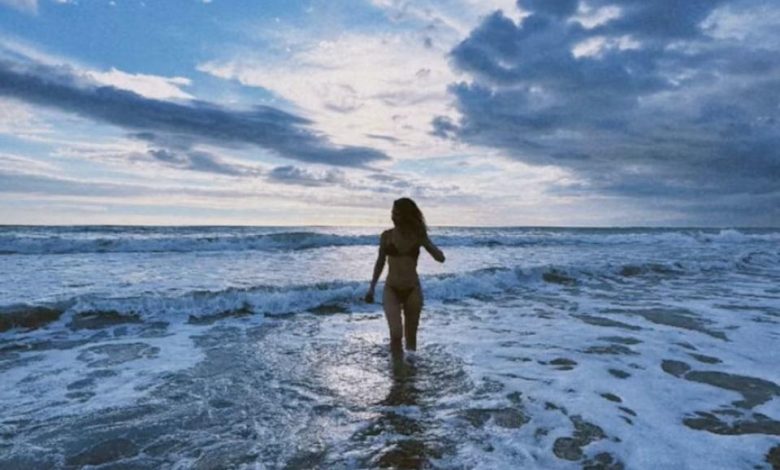 Lily James parada na praia.