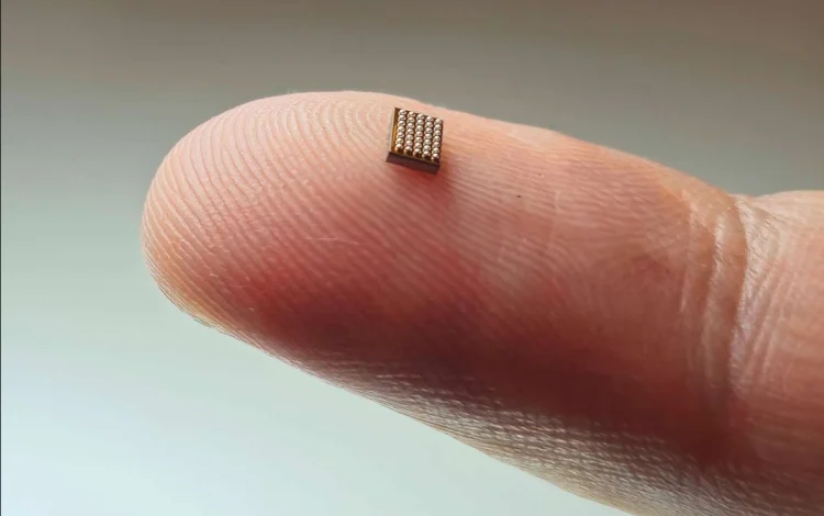 Um minúsculo microchip de IA fica no topo de um dedo.