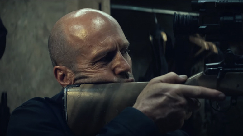 Levon de Statham segurando um rifle em A Working Man