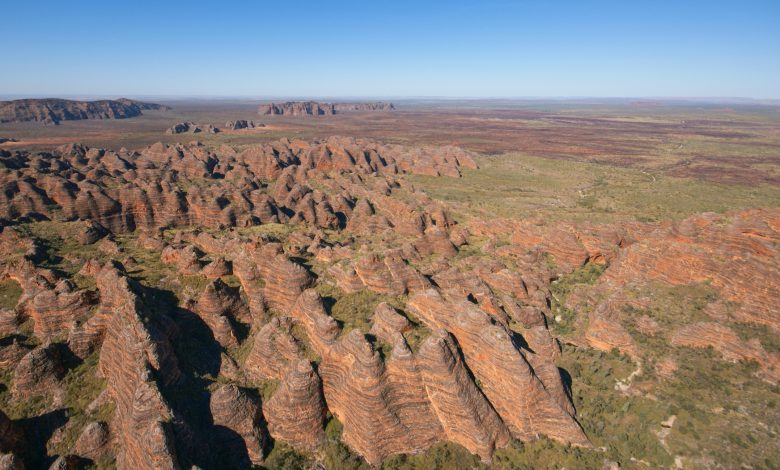 Vista aérea grande angular da cordilheira Bungle Bungle, na Austrália Ocidental. Não vemos nada à distância, exceto uma planície árida e plana.