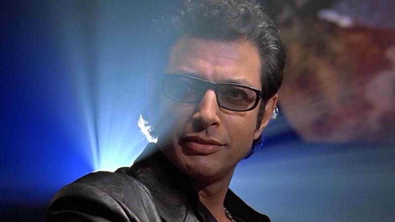 Ian Malcolm em frente à luz de um projetor