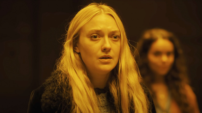 Mina / Lucy de Dakota Fanning parece assustada ao ser iluminada por luz amarela em The Watchers