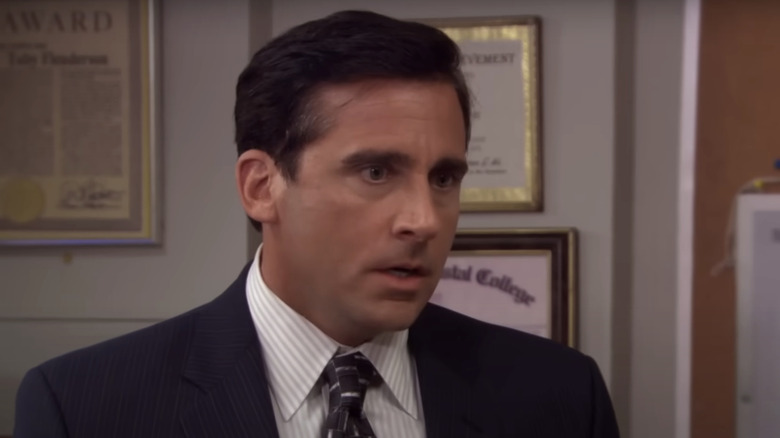 Michael Scott está no escritório da Dunder Mifflin vestindo um terno no The Office