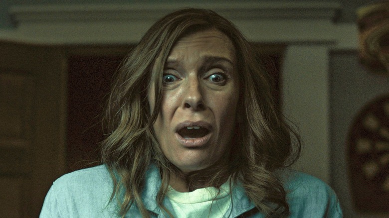 Toni Collette como Annie, reagindo a algo horrível em Hereditário