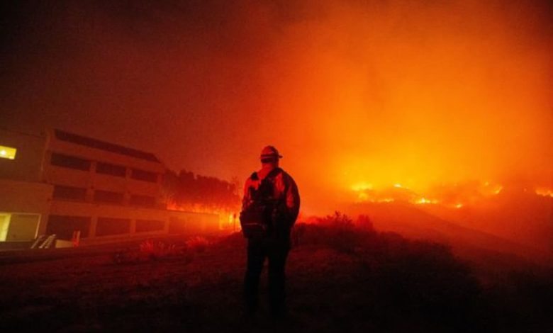 Um bombeiro observa enquanto o Franklin Fire queima em Malibu, Califórnia